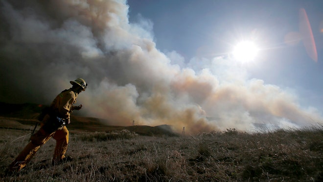  A pair of tamed but persistent wildfires still burned in the hills and mountains around Interstate  after a wild week of burning brush in the area north of Los Angeles.